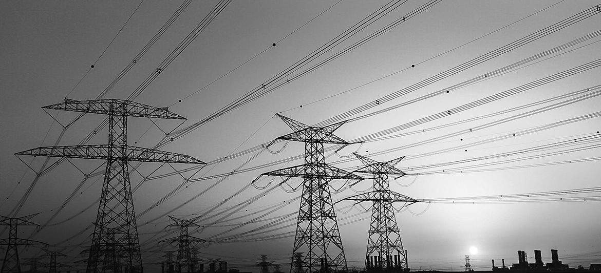 Electrical Pylons against vibrant twilight colors and a gorgeous sunset over Dubai Horizon.